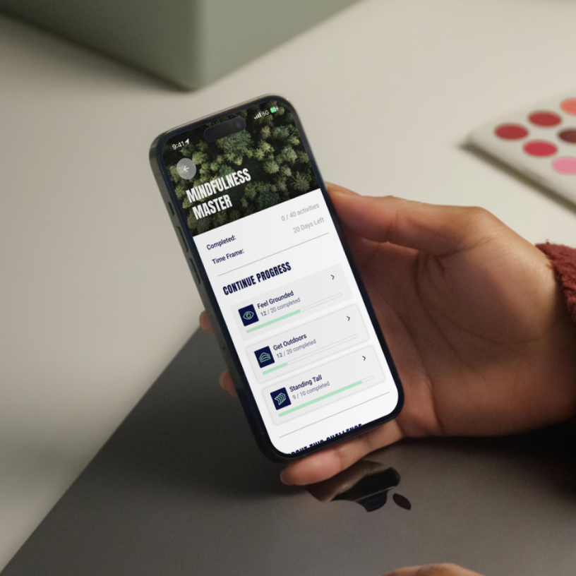 Person holding a mobile phone with Peak State app